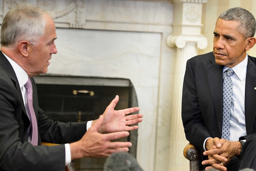 Barack Obama listens to Malcolm Turnbull, gesturing with both hands, during a meeting in the Oval Office.