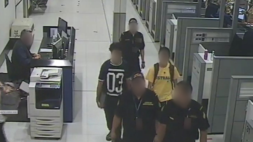 The two boys are escorted by officials in Sydney airport