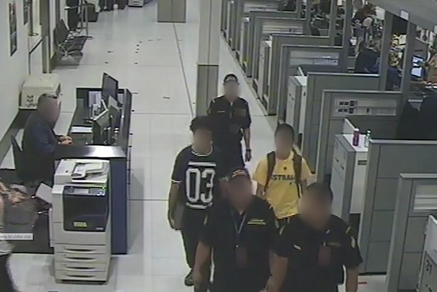 The two boys are escorted by officials in Sydney airport