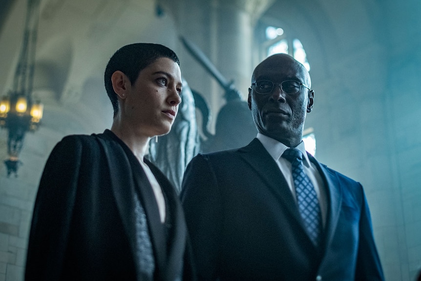 Colour close-up still of Asia Kate Dillon and Lance Reddick standing inside a cathedral in John Wick 3  John Wick: Chapter 3.