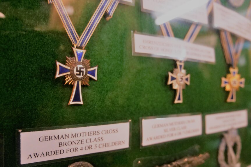 blue and gold coloured medallions with a swastika are framed on the wall