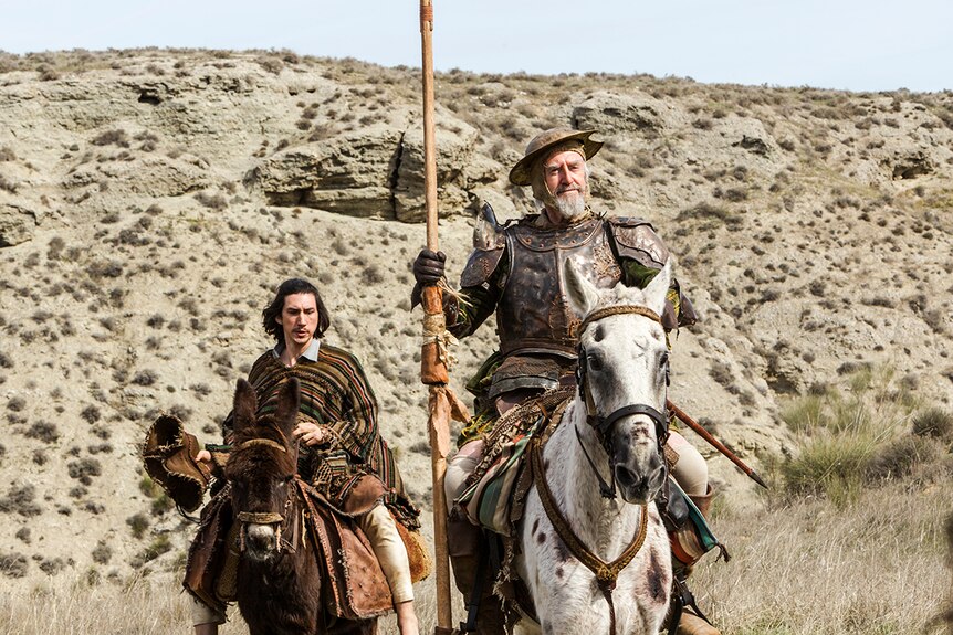 Colour still of Adam Driver and Jonathan Pryce riding through hilly landscape in 2018 film The Man Who Killed Don Quixote.