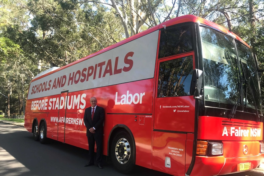 Opposition leader Luke Foley in front of his campaign bus - a large red bus.