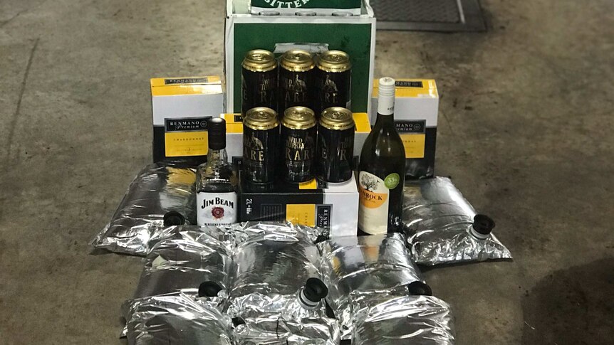 A pile of seized alcohol including several cask bladders and six-packs of beer