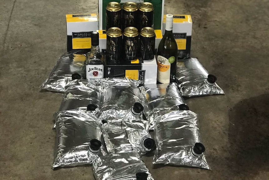 A pile of seized alcohol including several cask bladders and six-packs of beer