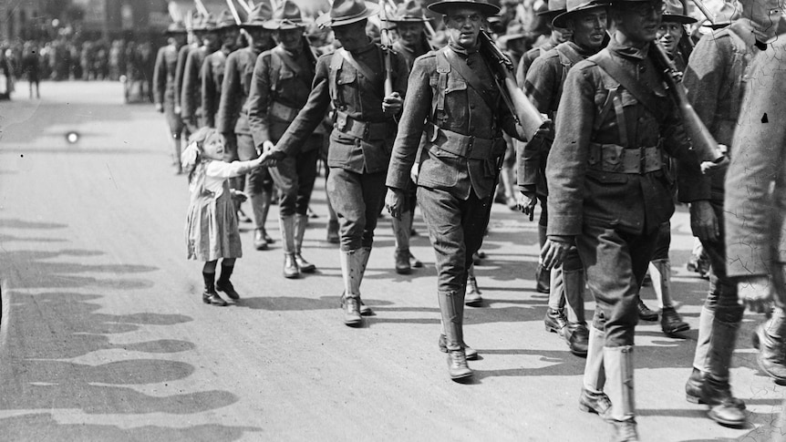 A little girls shakes the hand of an American soldier in London during WWI.