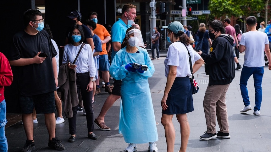 People wearing masks in a queue for a covid test