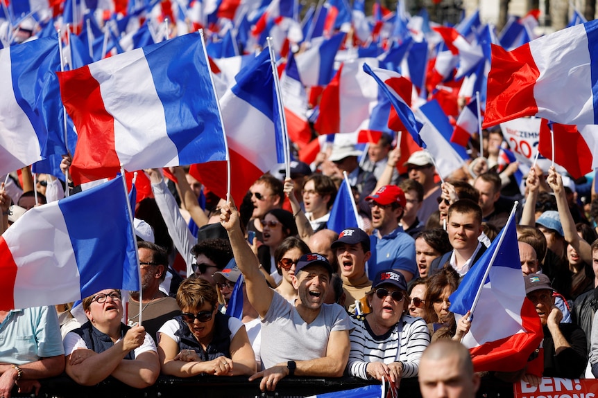 Supporters wave French flags.