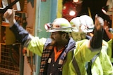 Todd Russell (L) and Brant Webb wave as they emerge from the mine lift