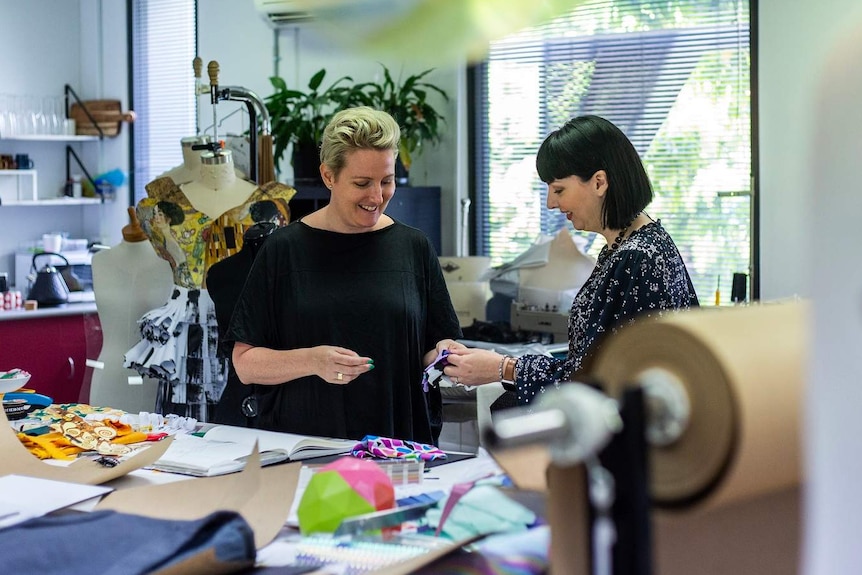 (LtoR) Jodie Hilton, with Laura Churchill, work in a sewing room.