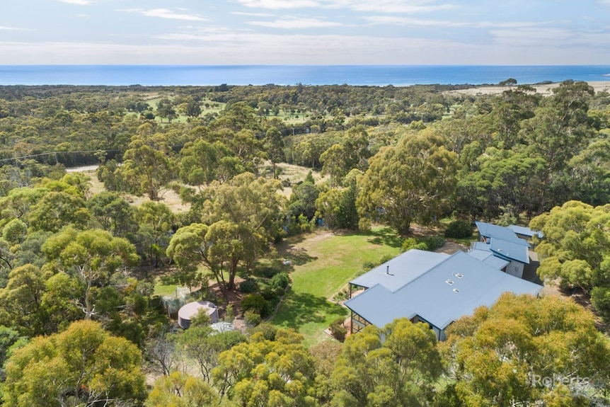 An aerial view shows how the property is surrounded by dense bushland.