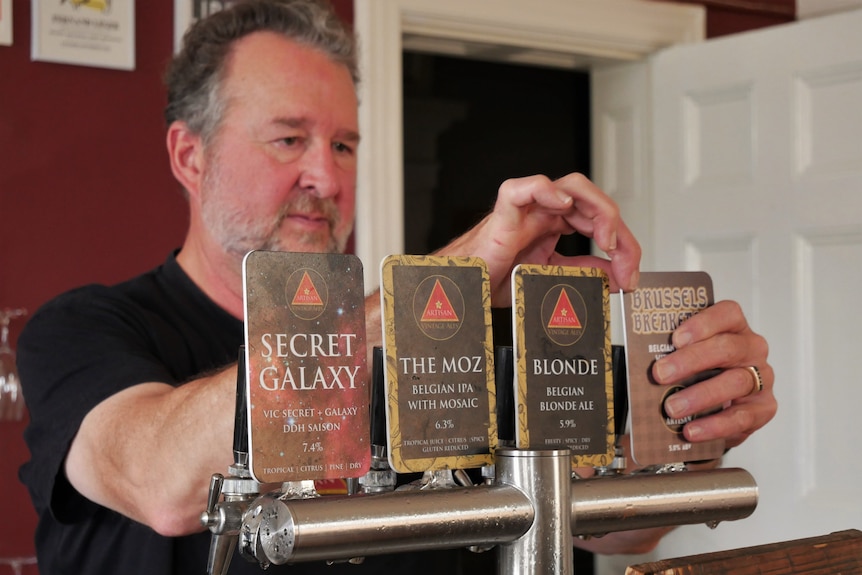 Man pours a beer behind a bar