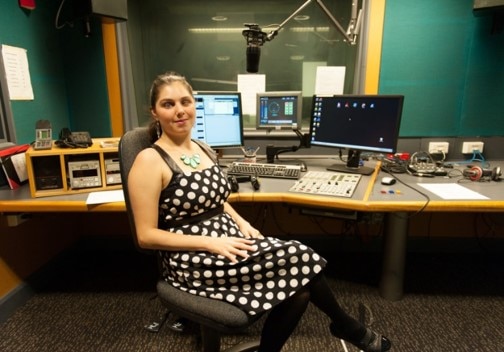 A smiling Nas Campanella sitting at her audio desk