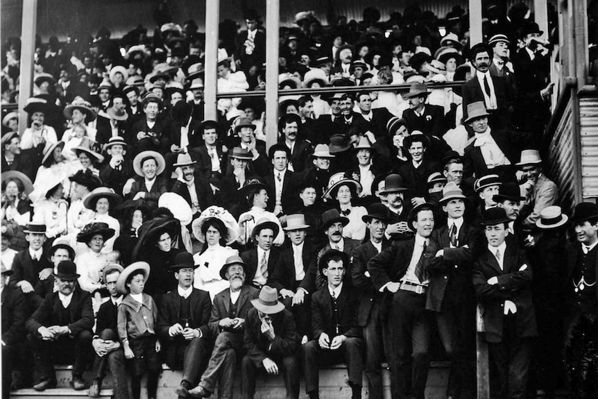 Black and white photo of crowd in a grand stand.