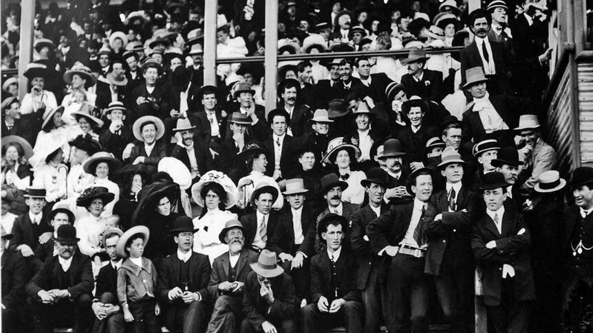 Black and white photo of crowd in a grand stand.