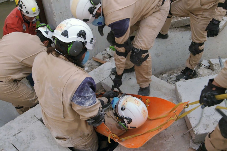 First responders on scene rescuing someone from rubble.