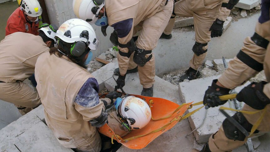 First responders on scene rescuing someone from rubble.