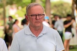 Prime Minister Anthony Albanese looking serious in headshot outside in a park
