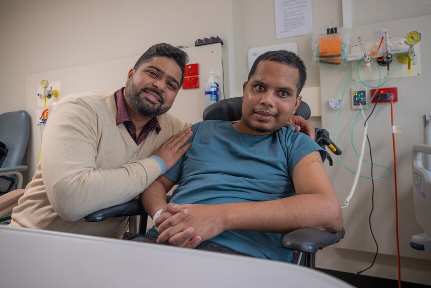 Two friends from India speaking in a hospital.