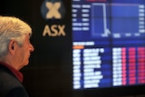An investor looks at the ASX board in Sydney