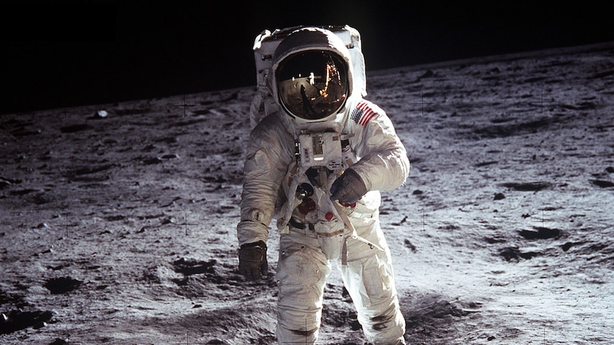 US astronaut Buzz Aldrin on the Moon, wearing a space suit with a reflective helmet.