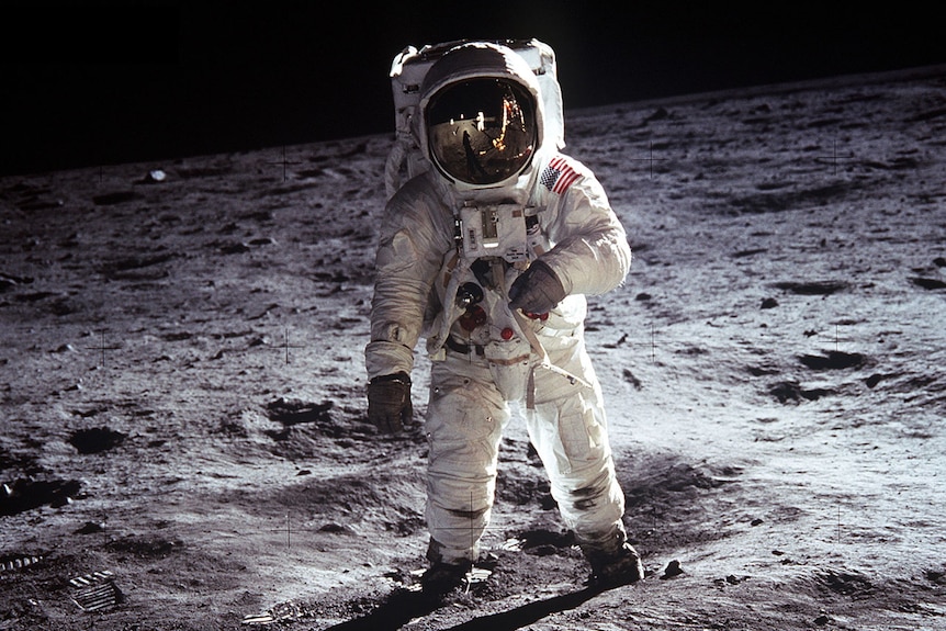 US astronaut Buzz Aldrin on the Moon, wearing a space suit with a reflective helmet.