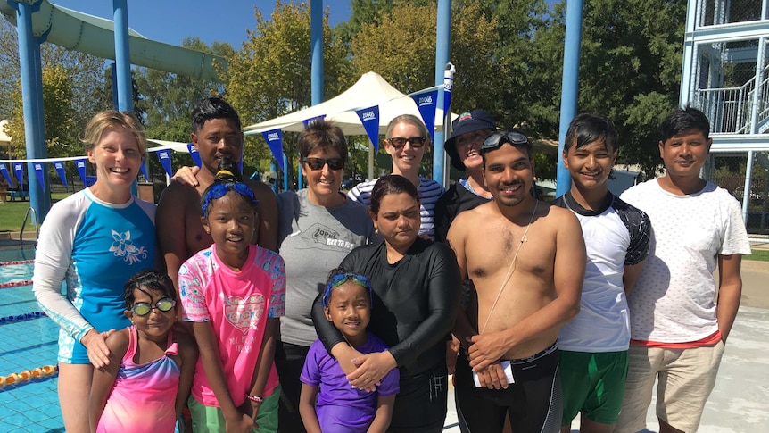 4 Australian swim teachers stand with 8 Nepalese people from Albury who are learning to swim.