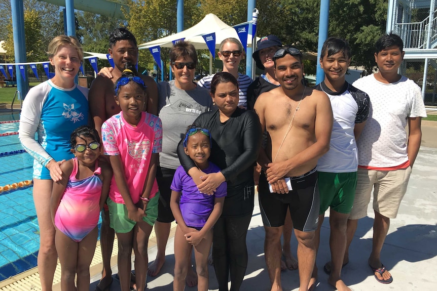 Four Australian swim teachers stand with eight Nepalese people from Albury who are learning to swim