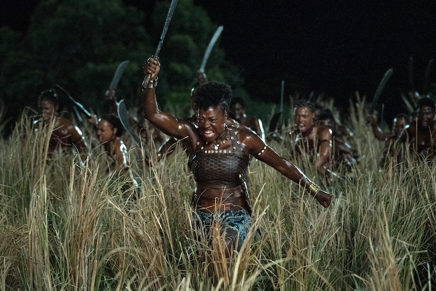 黑人妇女通过长毛积极地跑进战斗。 她把她的话穿在一件有弹性的衬衫里。