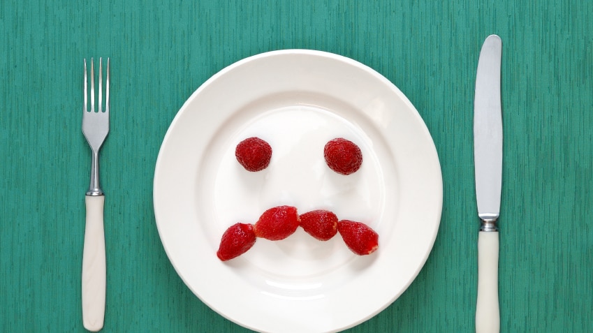 A plate with a sad face made out of berries.