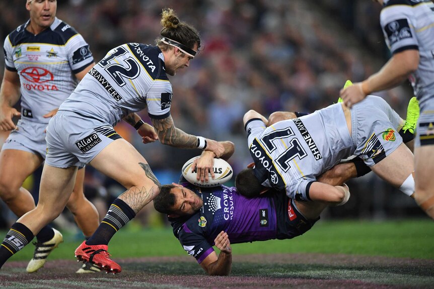 Cameron Smith is tackled by Shaun Fensom.