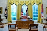The Resolute Desk, sitting empty in the Oval Office, surrounded by empty chairs
