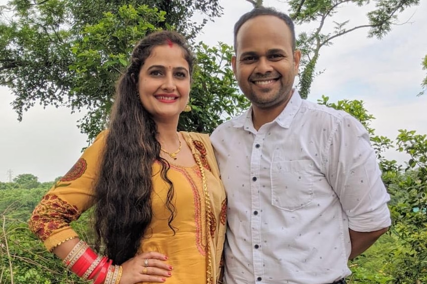 Queenslanders Neha Soni and Shailesh Thorat smile at the camera while standing outside