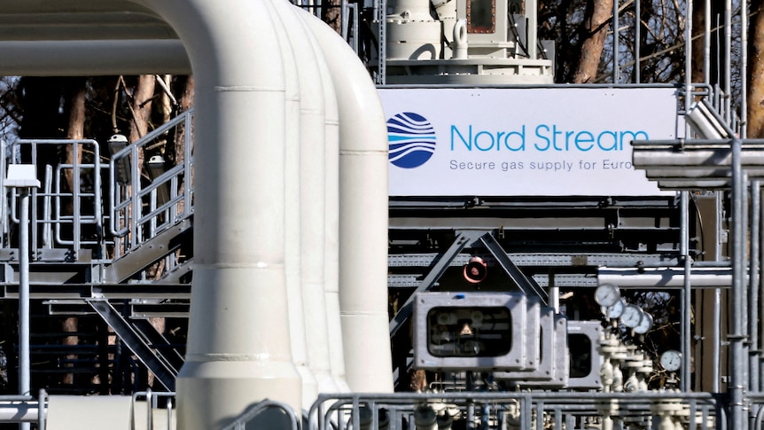 A series of large white pipes in front of Nord Stream sign.