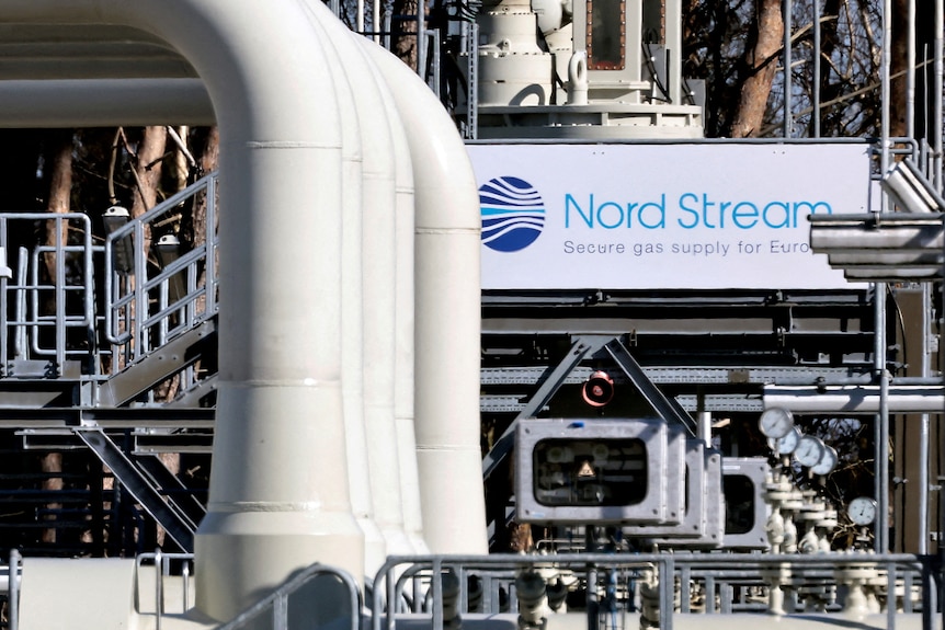 A series of large white pipes in front of Nord Stream sign.