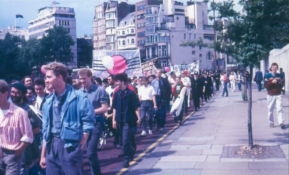 Grainy photo of a parade of mostly young men with banners through a London street