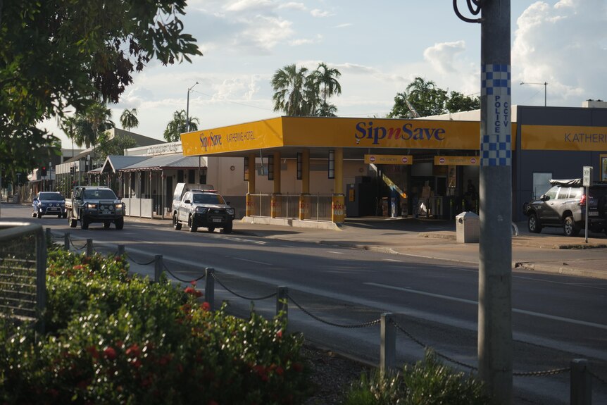 A 'Sip n Save' bottleshop with a police car parked out the front.  