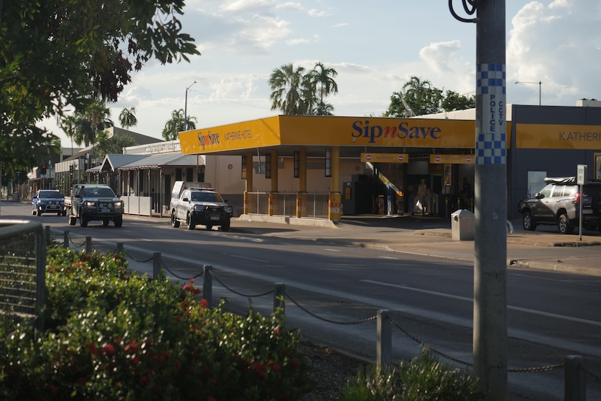 A 'Sip n Save' bottleshop with a police car parked out the front.  