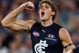 Charlie Curnow flexes his muscle and yells in delight