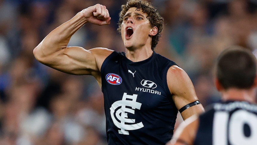 Charlie Curnow flexes his muscle and yells in delight