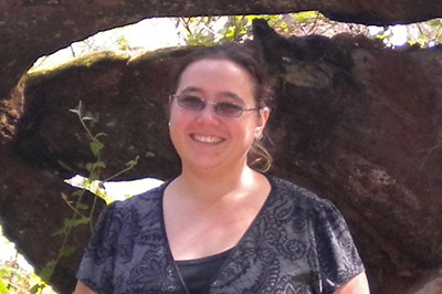 Woman in front of rocks in bush.