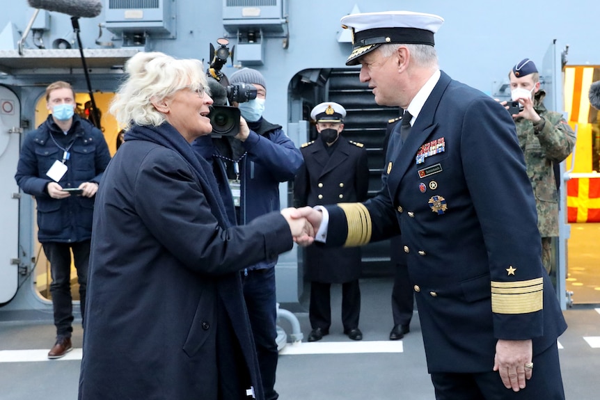 German Defence Minister Christine Lambrecht (C-L) is welcomed by vice-admiral Kay-Achim Schoenbach.