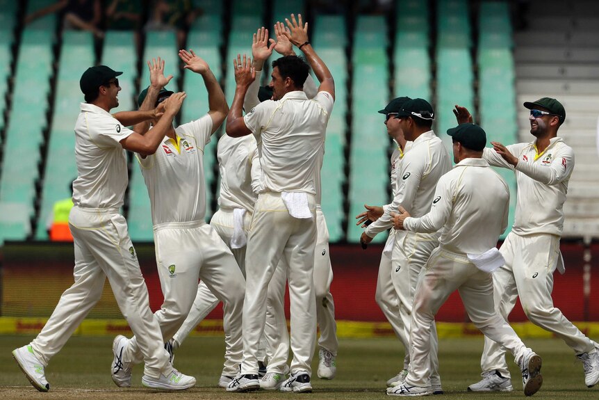 Mitchell Starc (C) is congratulated after removing South African batsman Dean Elgar.