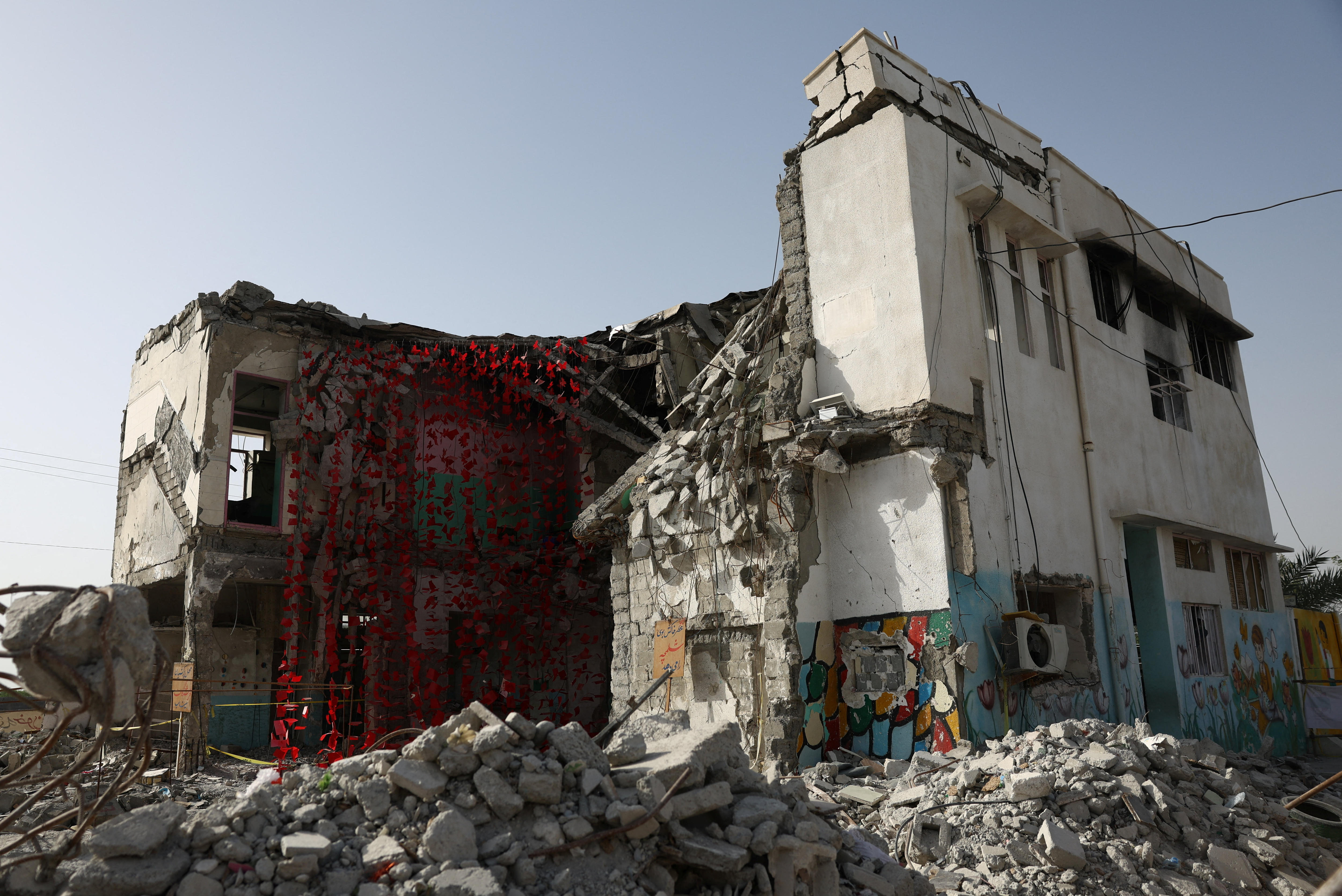 A school destroyed by a military strike. There is rubble on the ground. 