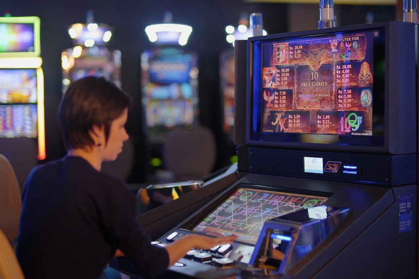 Anonymous woman sitting at electronic gaming machine.