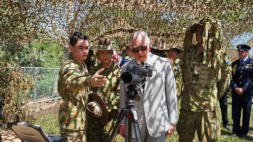 Prince Charles looks at equipment with soldiers