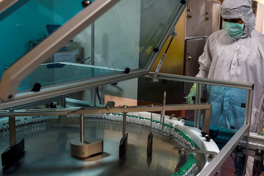 An employee in protective gear works on an assembly line