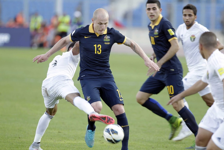 Jordan's Baha Abdel-Rahman (L) defends against Socceroos' Aaron Mooy (C, #13) in World Cup qualifier