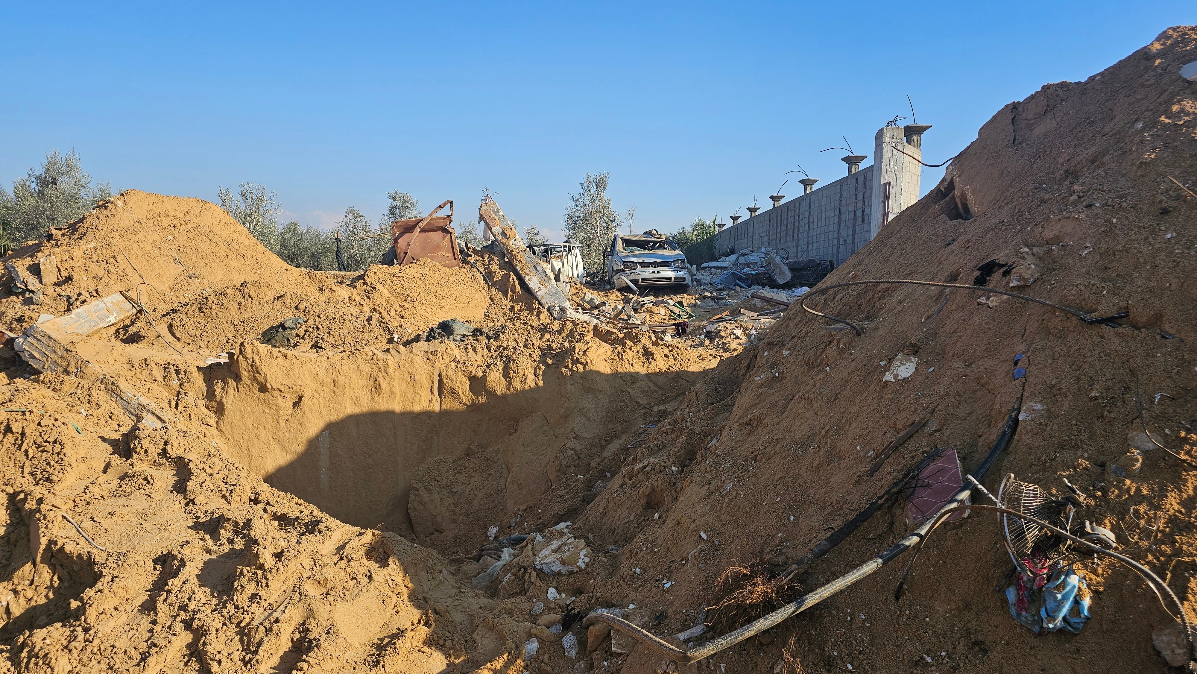Piles of dirt and debris surround a big hole in the ground.