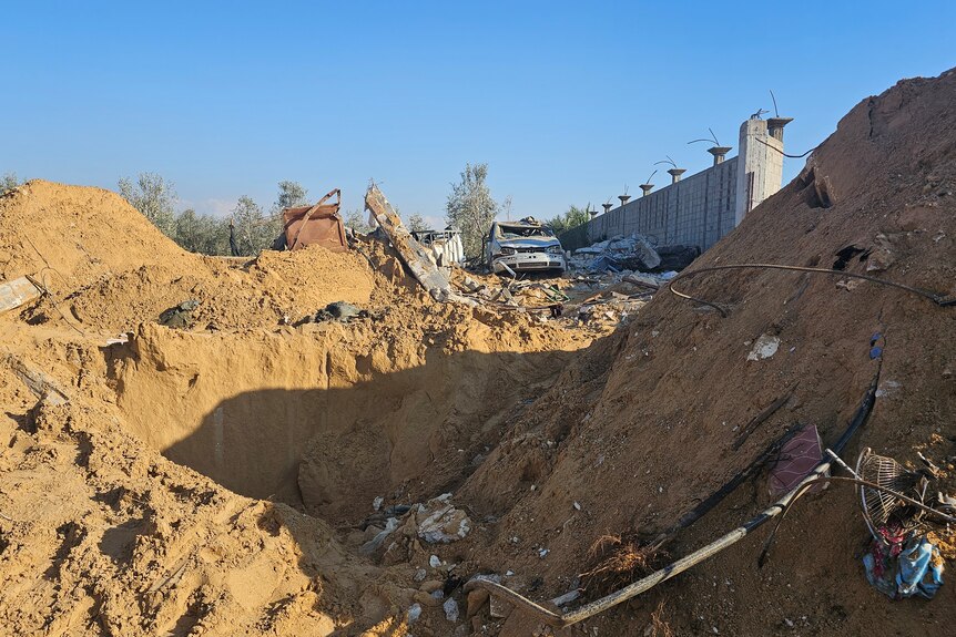 Piles of dirt and debris surround a big hole in the ground.
